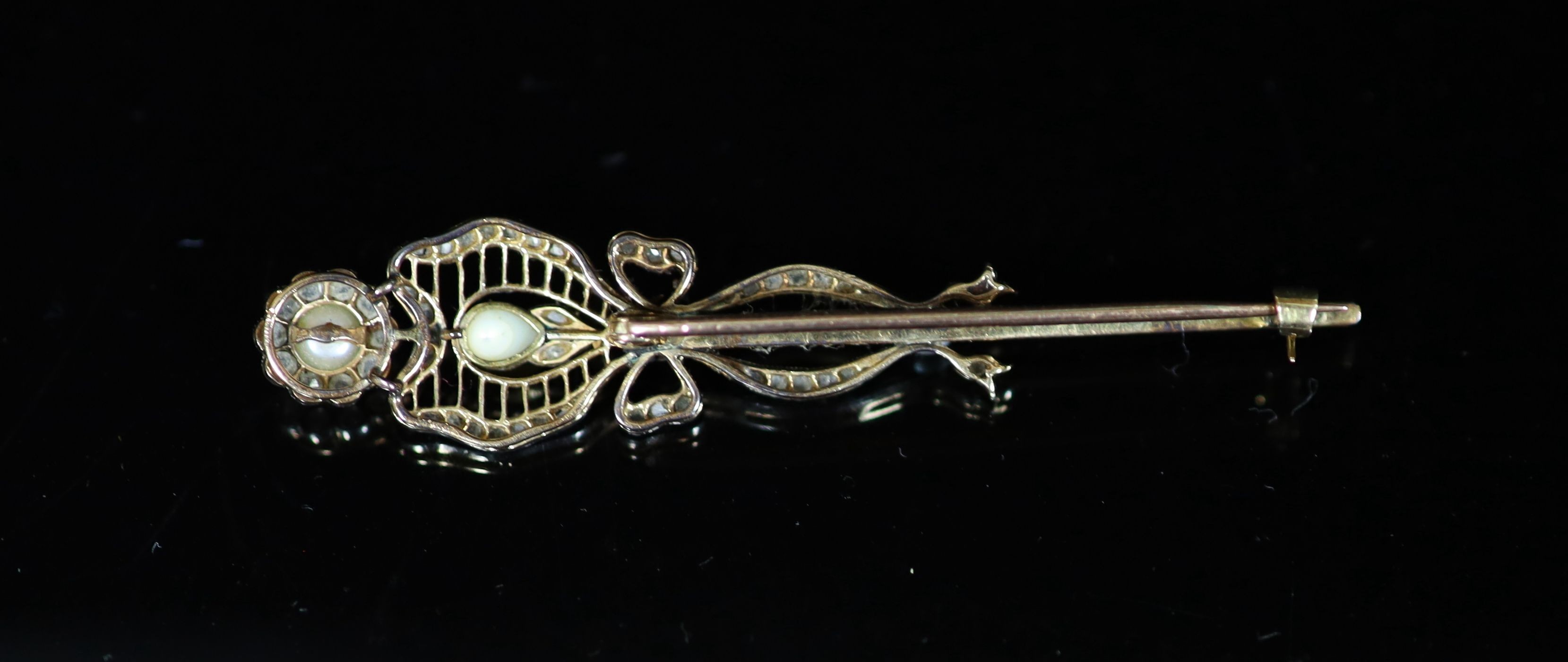 A Belle Epoque gold and platinum, rose cut diamond and pearl set open work flower head and ribbon brooch